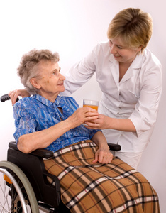 年轻护士鼓励轮椅上的老年妇女