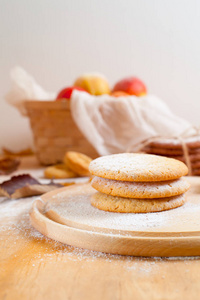 美国饼干糖粉圆木板，一筐苹果上, 轮包围秋天的浅色背景上的白色毛巾叶