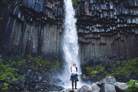 冰岛南部玄武岩柱包围 Svartifoss 瀑布的背景的人