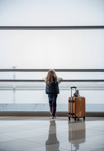 机场窗外的小女孩欣赏风景