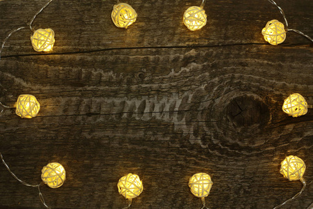 圣诞花环灯在旧木背景与复制空间为您的文本。顶部视图