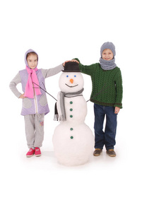可爱的男孩和女孩与雪人围巾和帽子