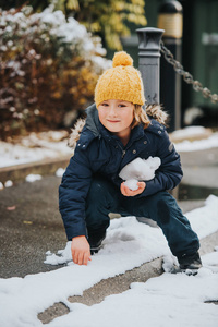 年轻的6岁男孩穿着暖和的夹克和靴子的户外肖像, 享受冬天的时间