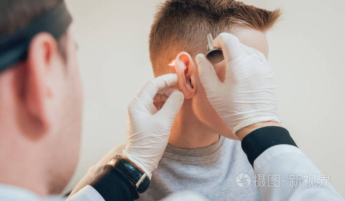 医生用耳镜检查男孩耳朵.医疗设备