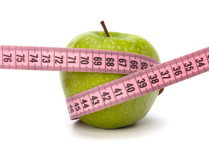 苹果带卷尺。 健康的生活方式概念。图片