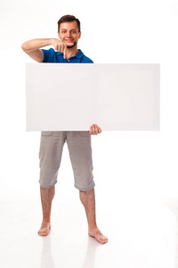 一个留着胡子的男人和一个白色的牌子可用于放置广告徽标等。穿着蓝色的 t恤和灰色的裤子