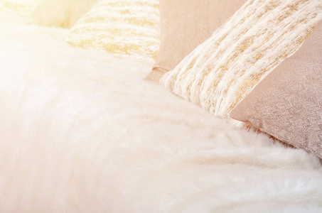 许多枕头躺在沙发上, 上面盖着一个大的毛绒面纱。