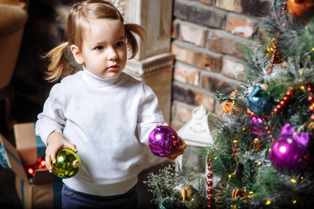 可爱的小女孩的美丽的相片2年在家装饰圣诞树