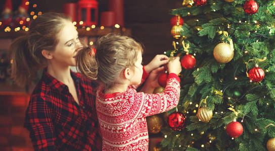 幸福家庭母亲和儿童女孩装饰圣诞树