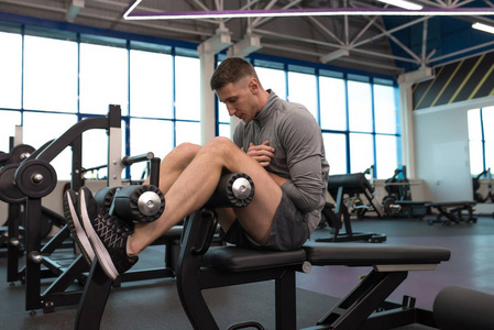 肌肉男在现代健身房锻炼时仰卧起坐的全长侧视图