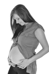 孕妇在白色背景下抚摸她的腹部