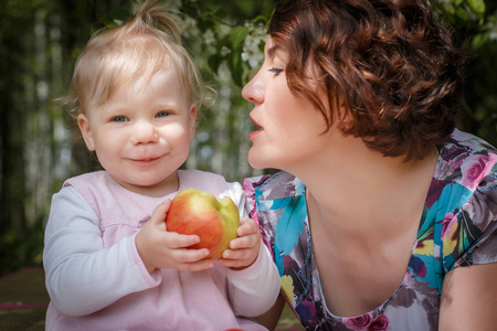 母亲和女儿与手中的苹果