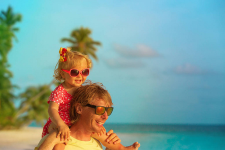 愉快的父亲和小女儿在热带海滩