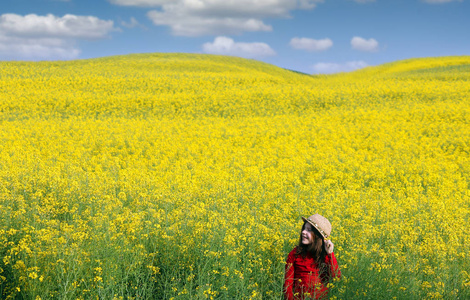 美丽的小女孩在黄色领域春天季节