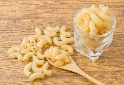 食物和菜 生肘通心粉或 Gomiti Pasta 在玻璃杯子和木勺子