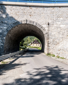 铁路 underbridge 以路和房子为背景