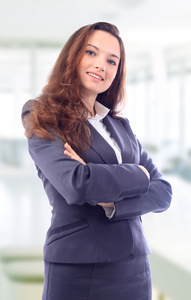 一位可爱的年轻商务女性在办公室微笑的肖像。