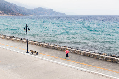 在海滨城市街道上奔跑的妇女
