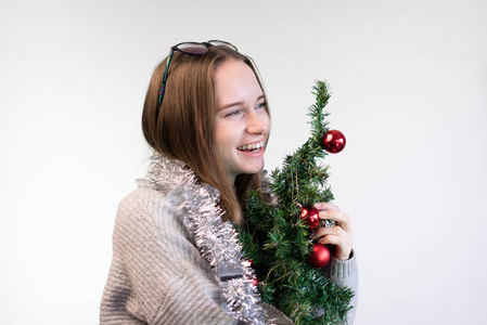 女孩与小圣诞树拥抱和微笑