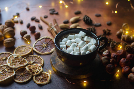 一杯传统的热巧克力或可可粉, 用棉花糖肉桂坚果和香料放在黑石桌上