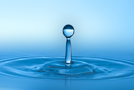 干净的蓝色水滴在清澈的水中飞溅。 抽象的蓝色