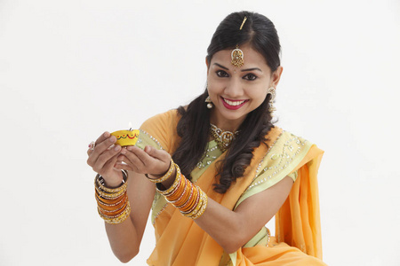 印度妇女在迷人的传统服装持有油灯