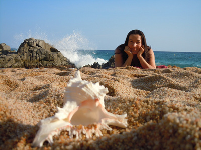 海滩上的年轻女子和贝壳