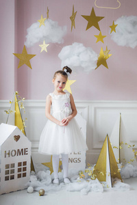 小快乐仙女或天使的节日主题魔术棒。美丽的白种小天使的肖像穿着白色的礼服和手持魔术棒