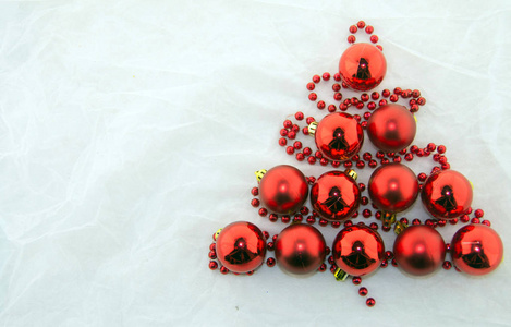 白色背景的红珍珠和闪亮的红球做成的圣诞树