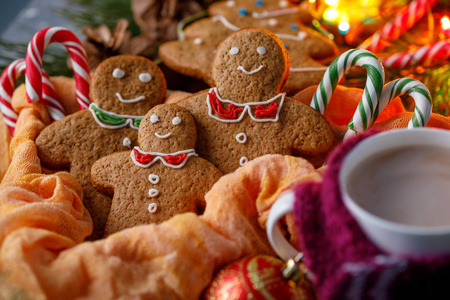 圣诞气氛的魔力。姜饼和热可可在一个欢快的围巾杯。滑稽微笑的小男人和糖果手杖