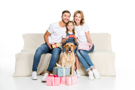 快乐的家庭和狗坐在沙发上的礼物, 孤立的白色