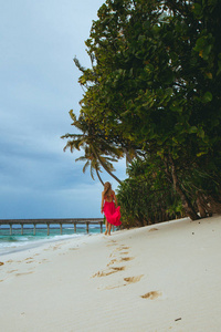 的女孩漫步在海滩上的热带天堂岛