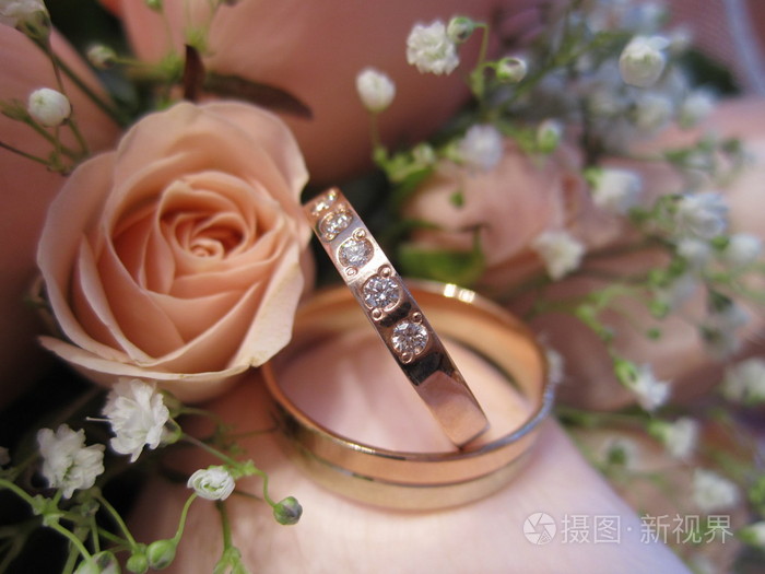 婚礼上的金戒指放在一束鲜花上,送给新娘照片-正版商用图片03qj0m-摄