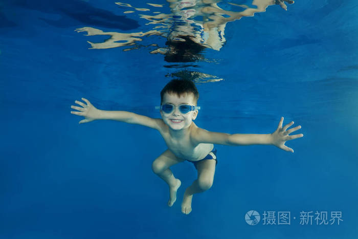 4年男孩游泳护目镜在水池水下玩耍