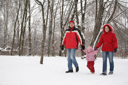 父亲和母亲在冬天和孩子一起在公园散步