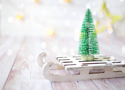 玩具雪橇上的圣诞树。木制背景下的圣诞和新年贺卡