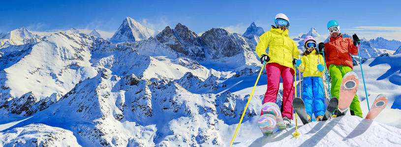 幸福的家庭享受寒暑假在山。滑雪太阳