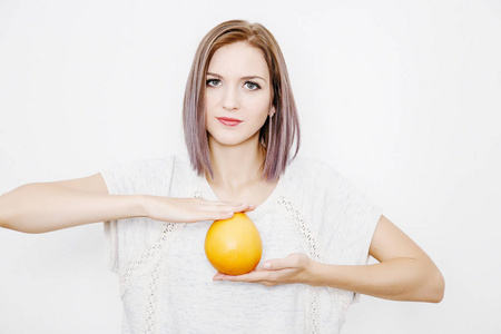 女人手里拿着柚子。年轻妇女与柑橘