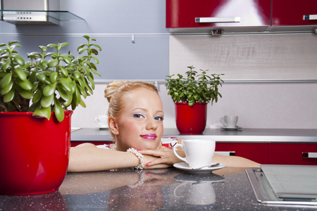 年轻漂亮的女性坐在厨房喝咖啡