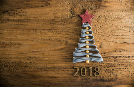 从复古风格的木质地的花边圣诞树。快乐2018新年贺卡