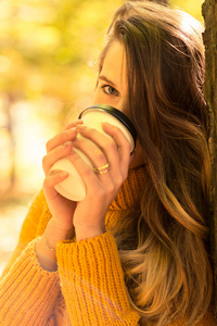 年轻女性在户外享用新鲜咖啡