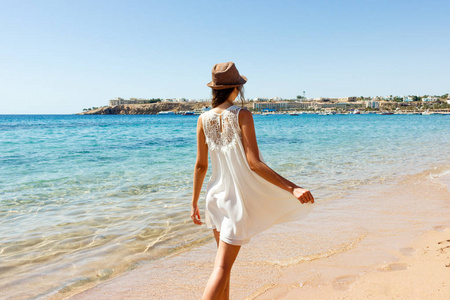 妇女快乐和快乐的白色礼服在海滩上