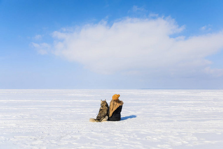 冬天结冰的海湾有雪橇狗的妇女