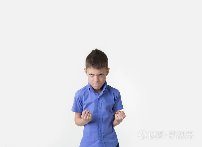 愤怒的小男孩用握紧的拳头上白色孤立