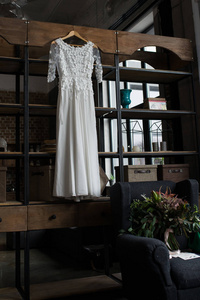 挂在柜子上的质朴的白色婚纱礼服。阁楼内饰