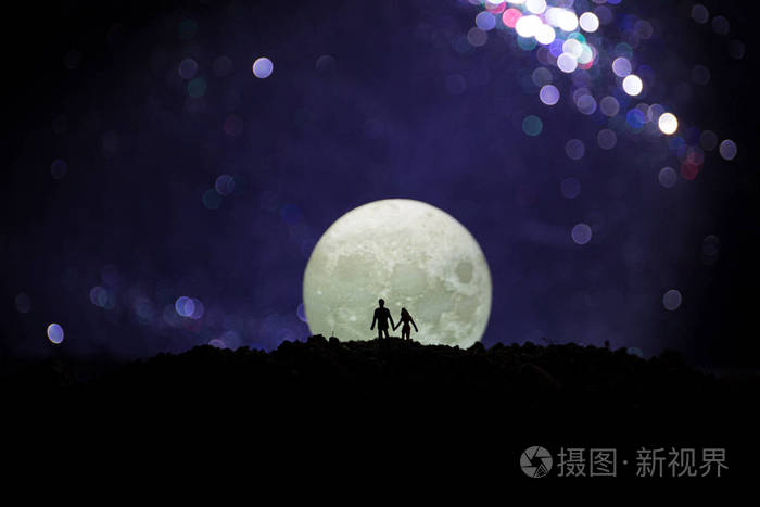 令人惊叹的爱情场面.年轻浪漫情侣的剪影站在月光下