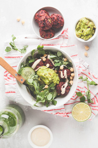 绿色蔬菜沙拉配甜菜肉丸, 鳄梨酱和芝麻酱敷料。健康素食的概念。复制空间