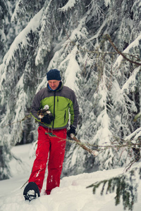 微笑的人, 手里拿着木柴的徒步旅行者在雪地里漫步
