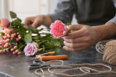 男性花店创造美丽的花束在桌子上, 特写