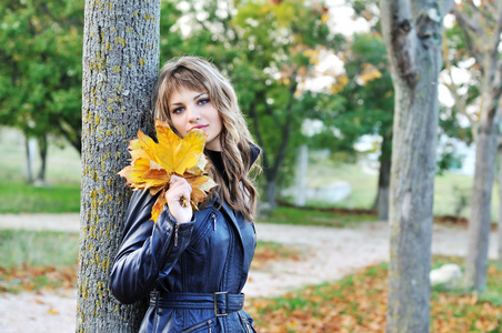 秋天一棵树附近的年轻女孩